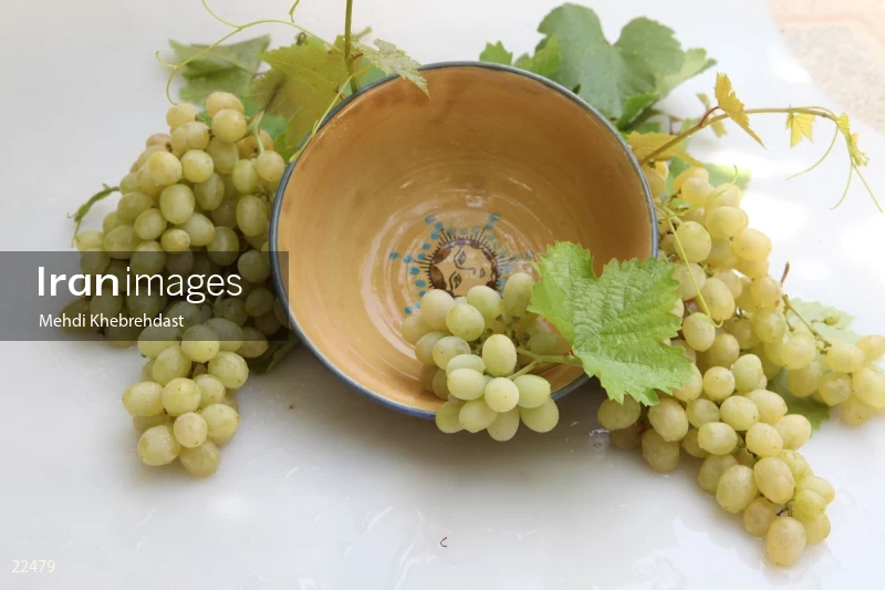 Bunch of green grapes in bowl on white background